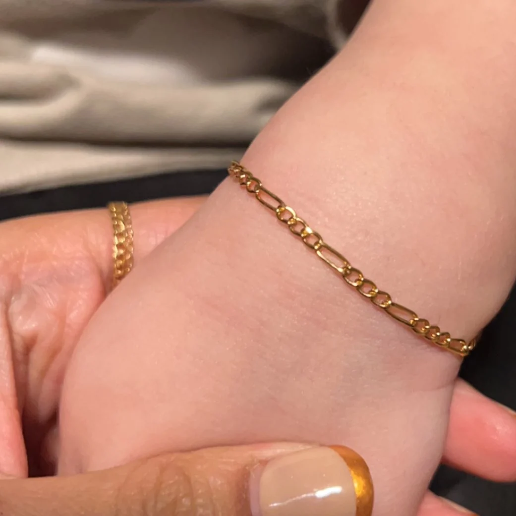 A small gold bracelet on a child's wrist