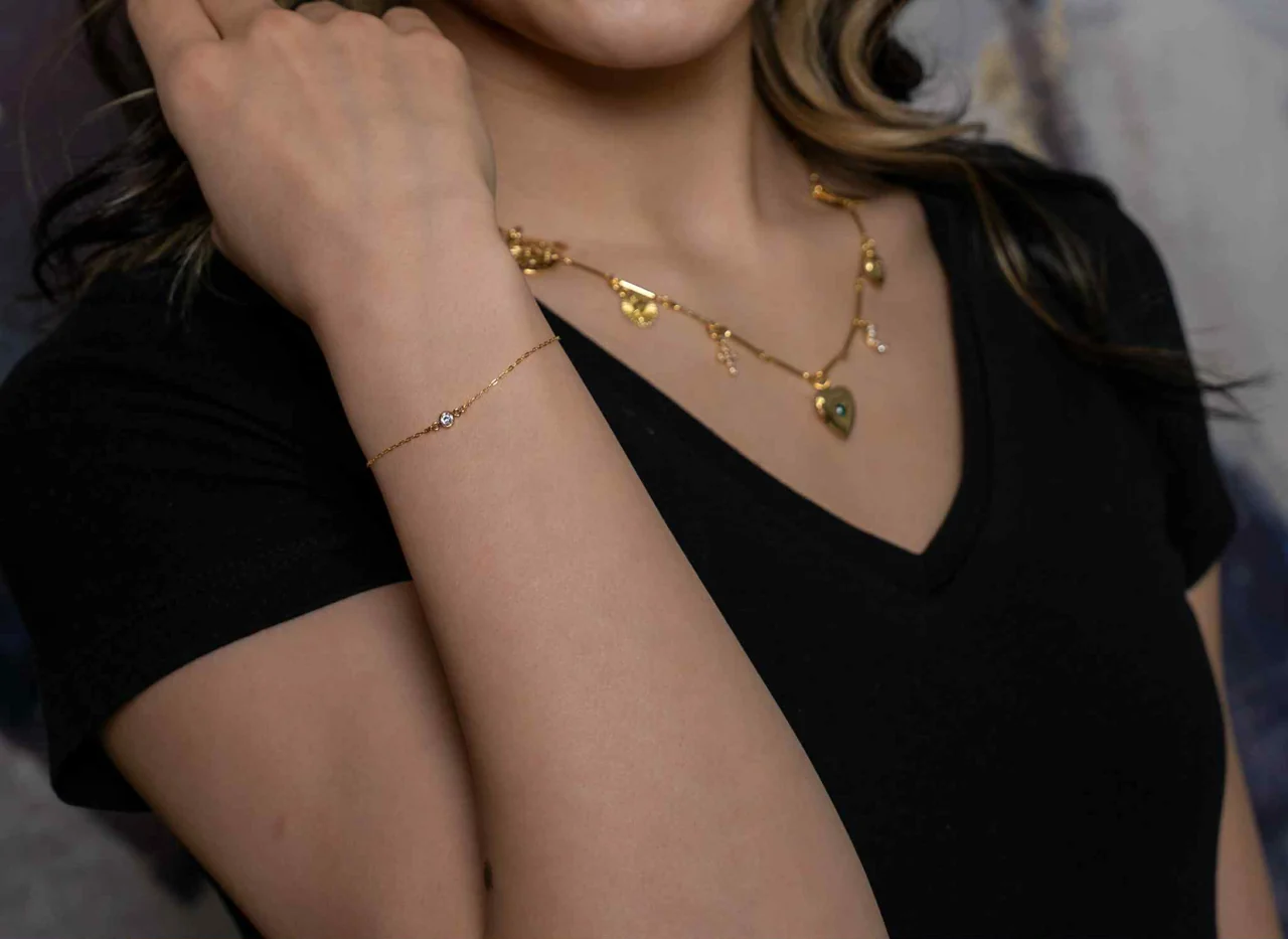 Layered gold necklaces worn with a black top